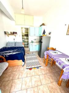 a kitchen with two beds and a table and a refrigerator at Stories of Samos beach studio 1 in Kámpos
