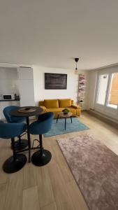 salon z dwoma stołami i żółtą kanapą w obiekcie Montreux centre ville lac appartement w mieście Montreux