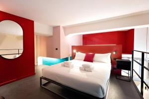 a bedroom with a large bed with a red wall at Margot - Color Apartment in Rome