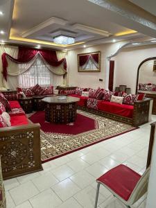 un salon avec des canapés rouges et une table dans l'établissement شقة في وسط المدينة هادئة ومناسبة للعائلات, à Charf