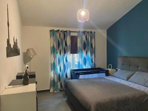 1 dormitorio con cama, escritorio y ventana en When in Maremma en Alberese