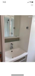 een badkamer met een wastafel en een spiegel bij Les Catalpas *** charmant mobilhome à louer in Saint-Georges-de-Didonne