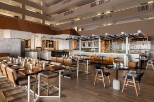 a restaurant with tables and chairs and a bar at Renaissance Denver Hotel & Conference Center in Denver +55 photos