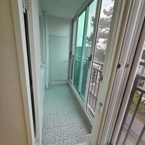 un corridoio con porta a vetri e balcone di Caty House Hyeopjae a Jeju