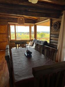 a wooden dining room with a table and a couch at Cabaña La Maura in La Estancia