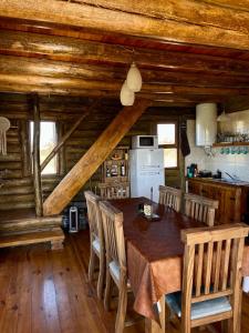 a dining room with a wooden table and chairs at Cabaña La Maura in La Estancia +22 photos