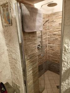 una doccia con porta in vetro in bagno di La Grotta a Napoli