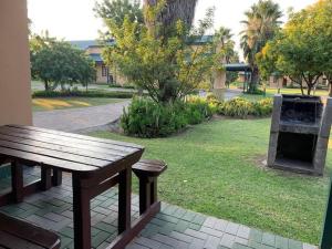 a picnic table and a grill in a park at 20 Pendleberry Holiday Resort in Bela-Bela