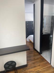 Habitación con cama, silla y espejo. en The Lofts Urbanos Manizales, en Manizales