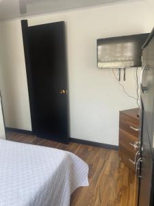 Un dormitorio con una cama y una puerta negra. en The Lofts Urbanos Manizales, en Manizales