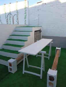 una mesa de picnic blanca y escaleras con césped verde en La posada del Kintsugi, en Pilas