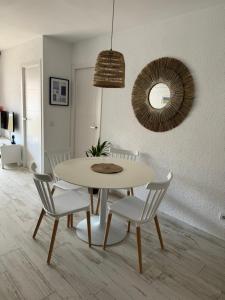 uma sala de jantar com uma mesa, cadeiras e um espelho em La Marinada em Cambrils
