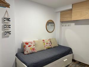 um pequeno quarto com uma cama e um espelho em La Marinada em Cambrils