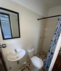 uma casa de banho com um WC, um lavatório e um espelho. em Hotel Rancho Grande em Barranquilla
