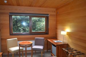 a room with a table and two chairs and a window at Puerto Chico Hotel in Puerto Varas