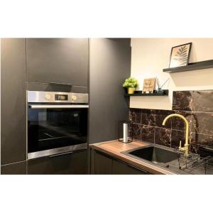 a kitchen with a sink and a stainless steel oven at Stunning stay 6 minutes from NEC and Birmingham Airport in Solihull
