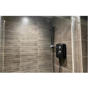 een douche met een zwarte zeepdispenser in een badkamer bij Stunning stay 6 minutes from NEC and Birmingham Airport in Solihull