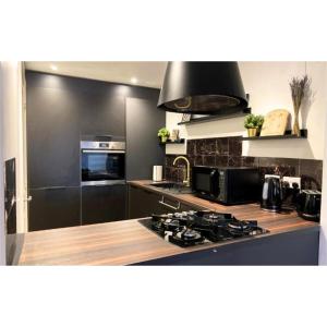 a kitchen with a stove and a black wall at Stunning stay 6 minutes from NEC and Birmingham Airport in Solihull