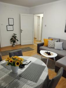 a living room with a couch and a table with flowers at Manila Apartment in Belgrade