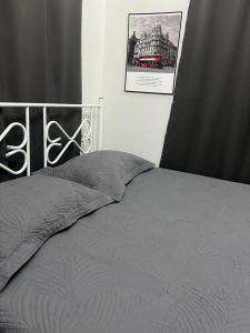 - un lit avec une couette grise dans une chambre dans l'établissement cfd homestay in dungun, à Dungun
