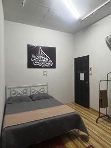 - une chambre avec un lit et une peinture murale dans l'établissement cfd homestay in dungun, à Dungun