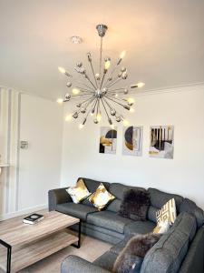 a living room with a couch and a chandelier at Private Parking, Urban Comfort & City Haven in Plymouth