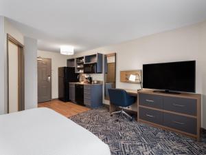 a hotel room with a bed and a flat screen tv at Candlewood Suites Radcliff - Fort Knox by IHG in Radcliff