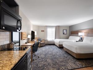 a hotel room with two beds and a flat screen tv at Candlewood Suites Radcliff - Fort Knox by IHG in Radcliff +51 photos