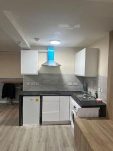 a kitchen with white cabinets and a stove top oven at studio flat in Spinney Hill