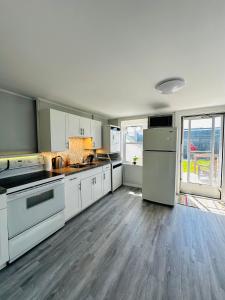 cocina con electrodomésticos blancos y ventana grande en Two story house with backyard, en Peterborough