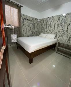 a bedroom with a bed and a stone wall at Hotel Rancho Grande in Barranquilla