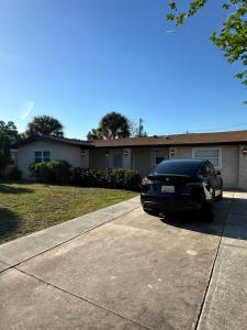 ein schwarzes Auto, das vor einem Haus parkt in der Unterkunft Private rooms in Spacious Siesta Key home - Huge Backyard in Sarasota