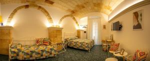 um quarto com duas camas e um sofá e cadeiras em La Terrazza Nel Borgo B&B em Copertino