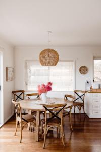 uma sala de jantar com uma mesa de madeira e cadeiras em Banksia Beach House em Port Fairy