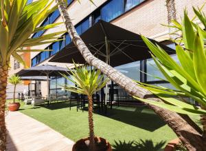 a courtyard with tables and chairs and a building at Hotel Málaga Alameda Centro Affiliated by Meliá in Málaga