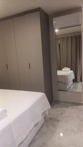 a bedroom with a white bed and a mirror at Studio Campo Belo 301 in Sao Paulo +7 photos