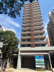 a tall building with a sign in front of it at Studio Campo Belo 301 in Sao Paulo