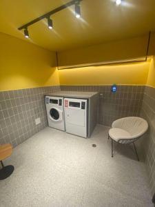 a laundry room with a washing machine and a chair at Studio Campo Belo 301 in Sao Paulo