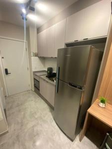 a kitchen with a stainless steel refrigerator and white cabinets at Studio Campo Belo 301 in Sao Paulo