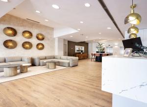 a lobby with couches and tables in a building at Hotel Málaga Alameda Centro Affiliated by Meliá in Málaga