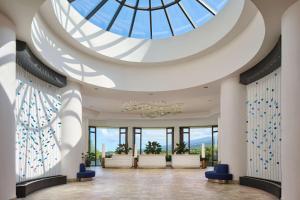 a lobby with a glass ceiling and blue chairs at Outrigger Kona Resort and Spa in Kailua-Kona