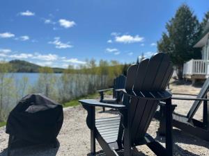 a group of chairs sitting next to a lake at Pimishka Chalet-Cottage-Studios in Bouchette