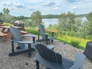 a group of chairs and a picnic table and a lake at Pimishka Chalet-Cottage-Studios in Bouchette +10 photos
