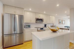 a kitchen with white cabinets and a stainless steel refrigerator at Sea Colony --- 1004S Edgewater House Road in Bethany Beach