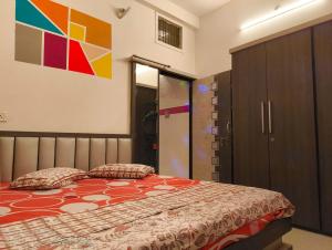 - une chambre avec un lit et une peinture murale dans l'établissement VIBGYOR, à Indore