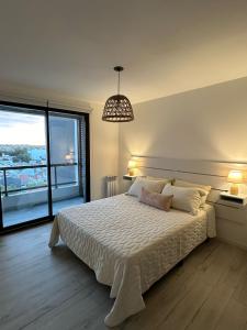 a bedroom with a bed and a large window at Departamento Paso 3244 in Mar del Plata +8 photos