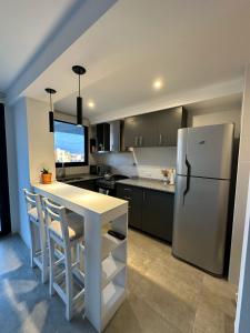 a kitchen with a white refrigerator and a table at Departamento Paso 3244 in Mar del Plata