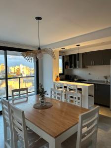 a kitchen and dining room with a wooden table and chairs at Departamento Paso 3244 in Mar del Plata