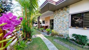 a house with a garden with purple flowers at Liturs house in Bacolod