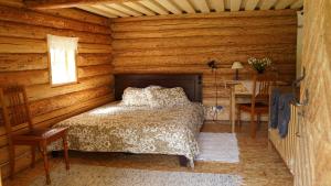 a bedroom with a bed in a log cabin at Hubane seto talu ait in Leimani